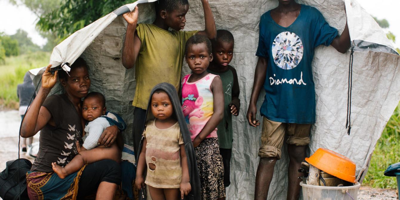 Maria, 31, with her six children with their only belongings sheltering from the rain by the side of the road. 24 hours before this photo was taken the rain came and the river banks burst causing their home to flood. Fearing another cyclone was coming they gathered all their life belongings and came to higher ground. Credit:Elena Heatherwick / Oxfam